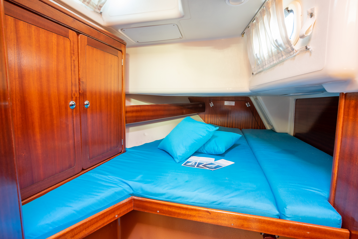 Forward cabin with blue bedding and storage