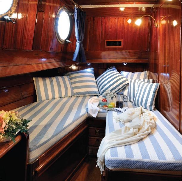 Sleeping quarters with blue and white striped bedding in a wooden cabin