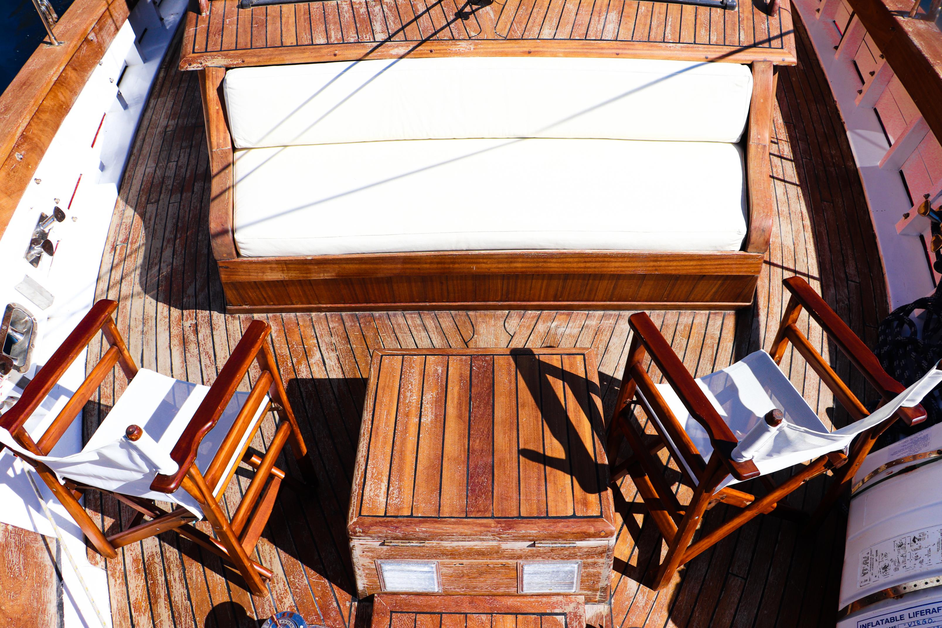 Deck view of Virgo with wooden decking and white cushioned seating